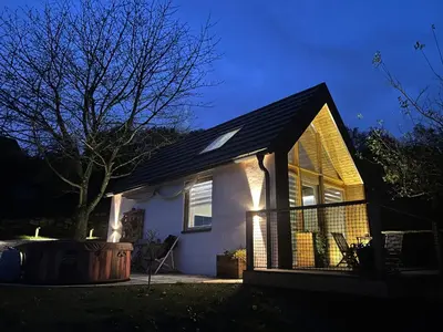a small white house with a black roof at Hiška pod črešnjo in Rogašovci