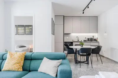 a living room with a blue couch and a kitchen at Adventure Oasis Bovec in Bovec