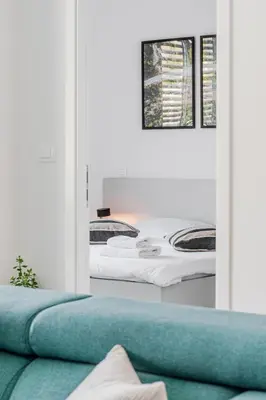 a room with two beds and a couch and a mirror at Adventure Oasis Bovec in Bovec
