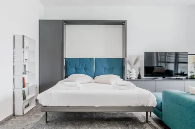 a bedroom with a large bed with a blue headboard at Adventure Oasis Bovec in Bovec