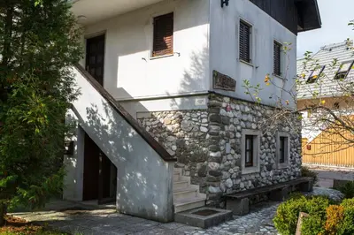 an external view of a stone building with a staircase at Guest house Vila Korošec in Bovec