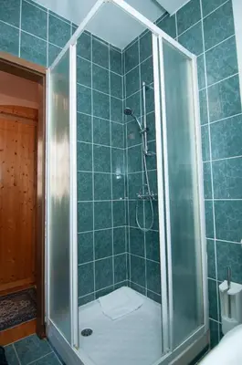 a shower with a glass door in a bathroom at Guest house Vila Korošec in Bovec