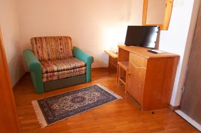 a living room with a chair and a television at Guest house Vila Korošec in Bovec