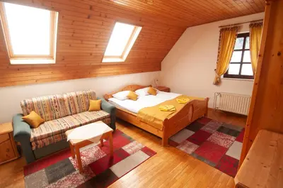 a bedroom with a bed and a couch in a room at Guest house Vila Korošec in Bovec