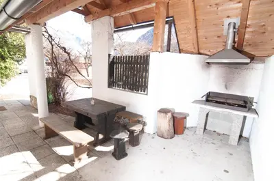 a patio with a picnic table and a grill at Guest house Vila Korošec in Bovec