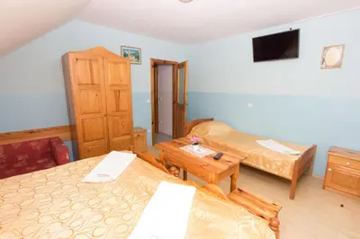 a small room with two beds and a tv at Guesthouse Kaučič in Benedikt v Slovenskih Goricah