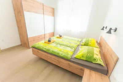a bedroom with a wooden bed with yellow sheets at Apartma Gojsa in Bovec