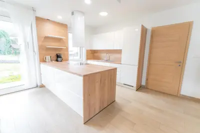 a kitchen with white cabinets and a wooden counter top at Apartma Gojsa in Bovec