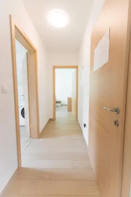a hallway with two doors and a wooden floor at Apartma Gojsa in Bovec