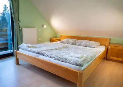 a bed with white sheets and pillows in a bedroom at Apartments Jasa in Mozirje