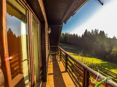 a balcony with a view of a field and trees at Apartments Jasa in Mozirje