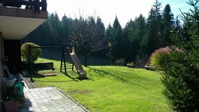 a playground in a yard with a slide at Apartments Jasa in Mozirje