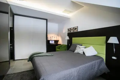 a bedroom with a large bed with a green headboard at Apartment Silver Deer, Kranjska Gora in Kranjska Gora