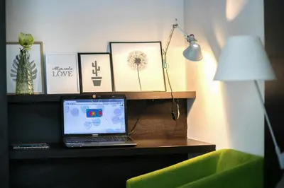 a laptop computer sitting on a desk next to a lamp at Apartment Silver Deer, Kranjska Gora in Kranjska Gora