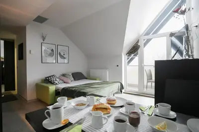 a living room with a bed and a table with food at Apartment Silver Deer, Kranjska Gora in Kranjska Gora