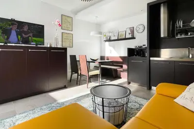 a kitchen and living room with a yellow couch and a table at Apartment Silver Deer, Kranjska Gora in Kranjska Gora