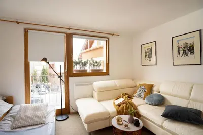 a living room with a white couch and a window at Ski Hut Smučka in Kranjska Gora