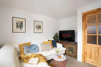 a living room with a white couch and a tv at Ski Hut Smučka in Kranjska Gora