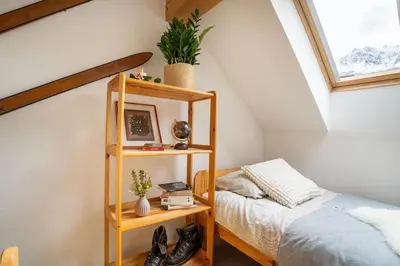 a attic bedroom with a bed and a book shelf at Ski Hut Smučka in Kranjska Gora