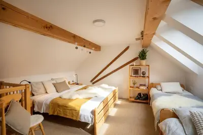 a attic bedroom with two beds and a chair at Ski Hut Smučka in Kranjska Gora