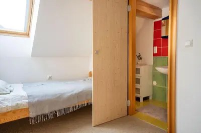 a bedroom with a bed and a bathroom with a sink at Ski Hut Smučka in Kranjska Gora