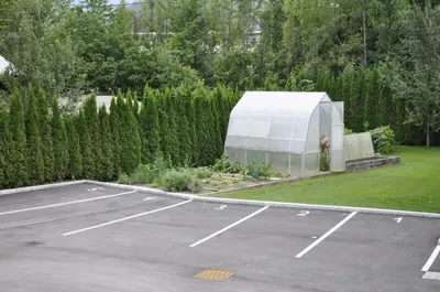 a parking lot with a large white greenhouse at Apartments Bledea in Bled