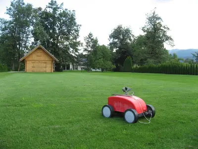 a red toy car sitting in the middle of a field at Apartments Bledea in Bled