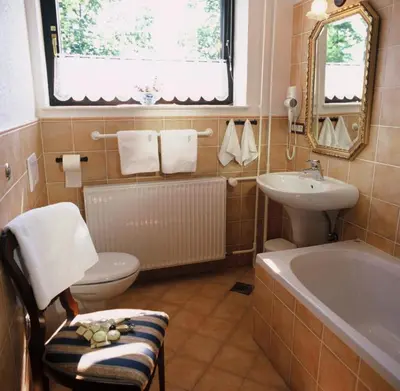 a bathroom with a toilet and a sink and a tub at Apartments Bledea in Bled