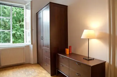 a bedroom with a dresser and a lamp next to a window at Apartment REZIDENCA GOGA in Novo Mesto