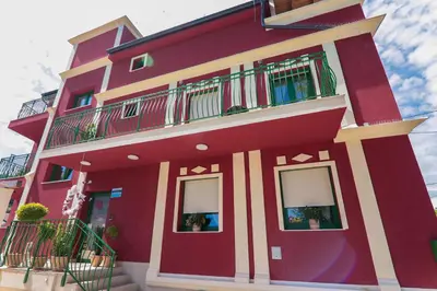 a red building with windows and balconies at APART HOTEL ASTERIA in Ljubljana