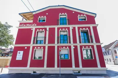 a red building with white trim on a street at APART HOTEL ASTERIA in Ljubljana