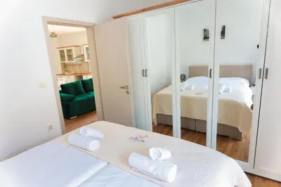 a bedroom with two beds and a mirror at APART HOTEL ASTERIA in Ljubljana