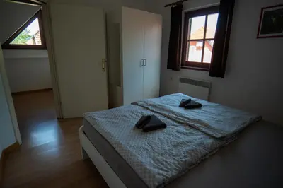 a bedroom with a bed with two black slippers on it at Apartment 47 Sara, Terme Čatež in Čatež ob Savi