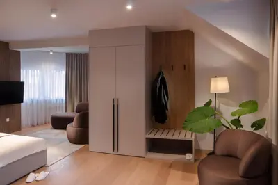 a bedroom with a large white wardrobe and a bed at HIŠA PUTR in Trzin