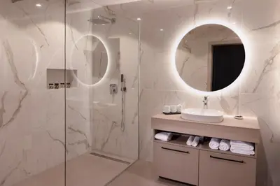 a bathroom with a shower and a sink and a mirror at HIŠA PUTR in Trzin