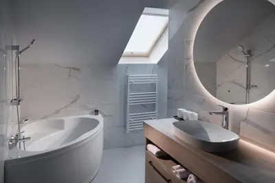 a bathroom with a tub and a sink and a mirror at HIŠA PUTR in Trzin