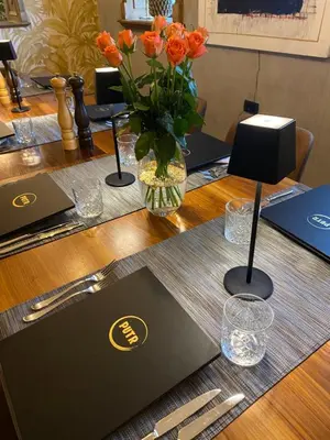a table with a vase of orange flowers on it at HIŠA PUTR in Trzin