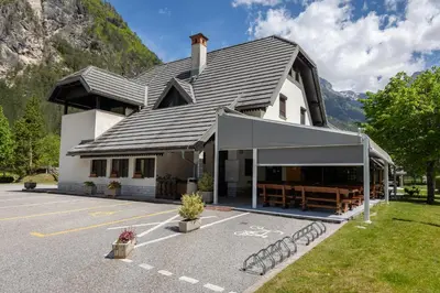 a large white building with a parking lot at Metoja in Soča