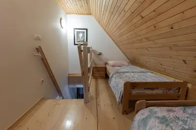 two beds in a room with a wooden ceiling at Metoja in Soča