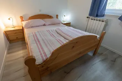 a bedroom with a wooden bed with a wooden floor at Metoja in Soča