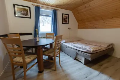 a room with a table and chairs and a bed at Metoja in Soča