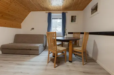 a living room with a table and chairs and a couch at Metoja in Soča