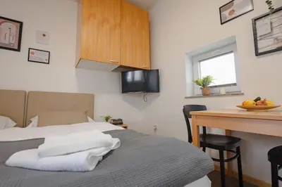a bedroom with a bed and a desk with a table at VILA KLARA apartments in Ljubljana