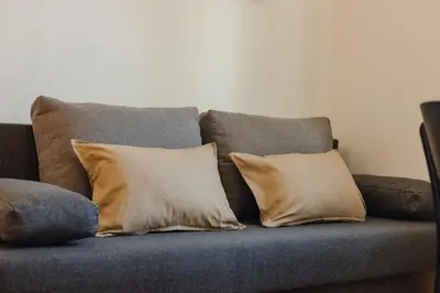 a couch with three pillows on it at VILA KLARA apartments in Ljubljana