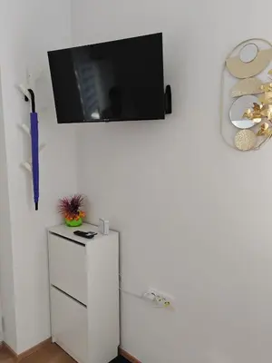 a flat screen tv hanging on a white wall at YELLOW APARTMENT WITH FREE PARKING in Ljubljana