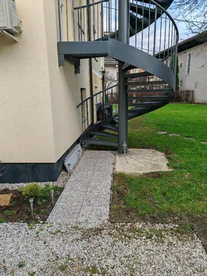 a spiral staircase in front of a building at YELLOW APARTMENT WITH FREE PARKING in Ljubljana
