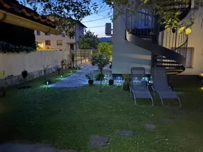 a yard with two chairs and a staircase at night at YELLOW APARTMENT WITH FREE PARKING in Ljubljana
