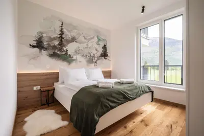 a bedroom with a bed and a large window at Soca Valley Suites in Bovec