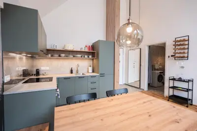 a kitchen with blue cabinets and a wooden floor at Soca Valley Suites in Bovec
