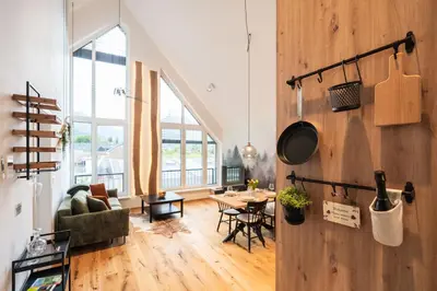 a living room with a wooden wall and a table at Soca Valley Suites in Bovec